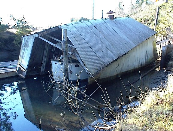 Deteriorated boathouse collapsing into the water