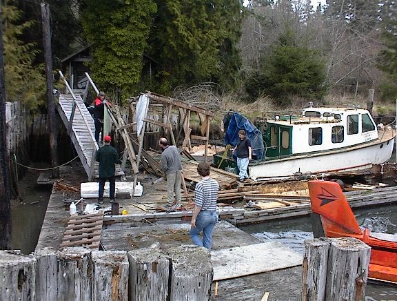 Family working on the dock during boathouse demolition