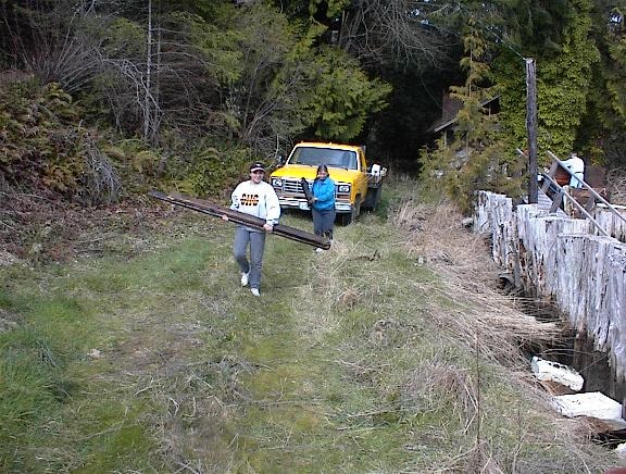 Family carrying materials away from the boathouse site