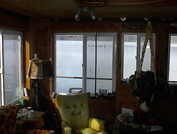 Interior of a houseboat living room with large windows overlooking the water